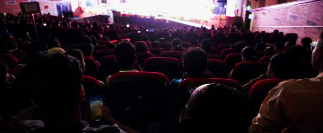 Audience watching a film in a darkened cinema
