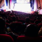 Audience watching a film in a darkened cinema