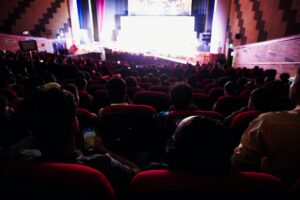 Audience watching must-watch movies in a darkened cinema