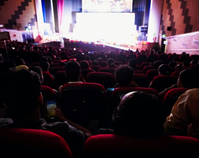 Audience watching a film in a darkened cinema