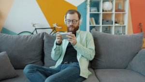 Person relaxing on couch browsing smartphone for entertainment
